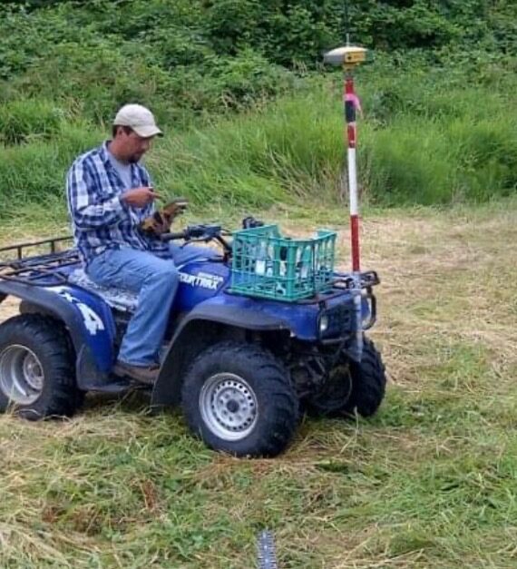 KLS surveyor collecting GPS data by ATV in open terrain
